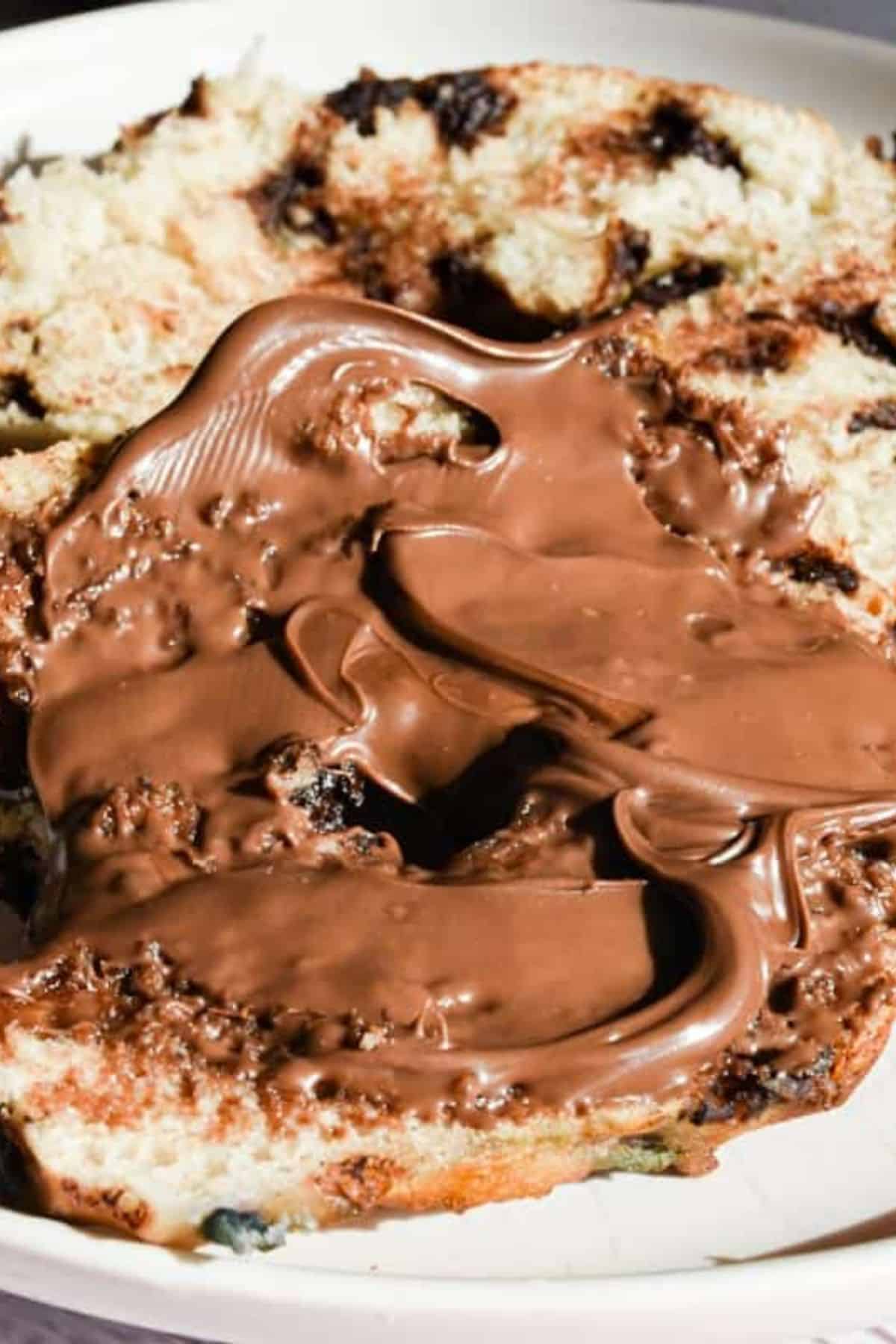 Creamy chocolate bread pudding with chunks of bread and chocolate drizzled on top.