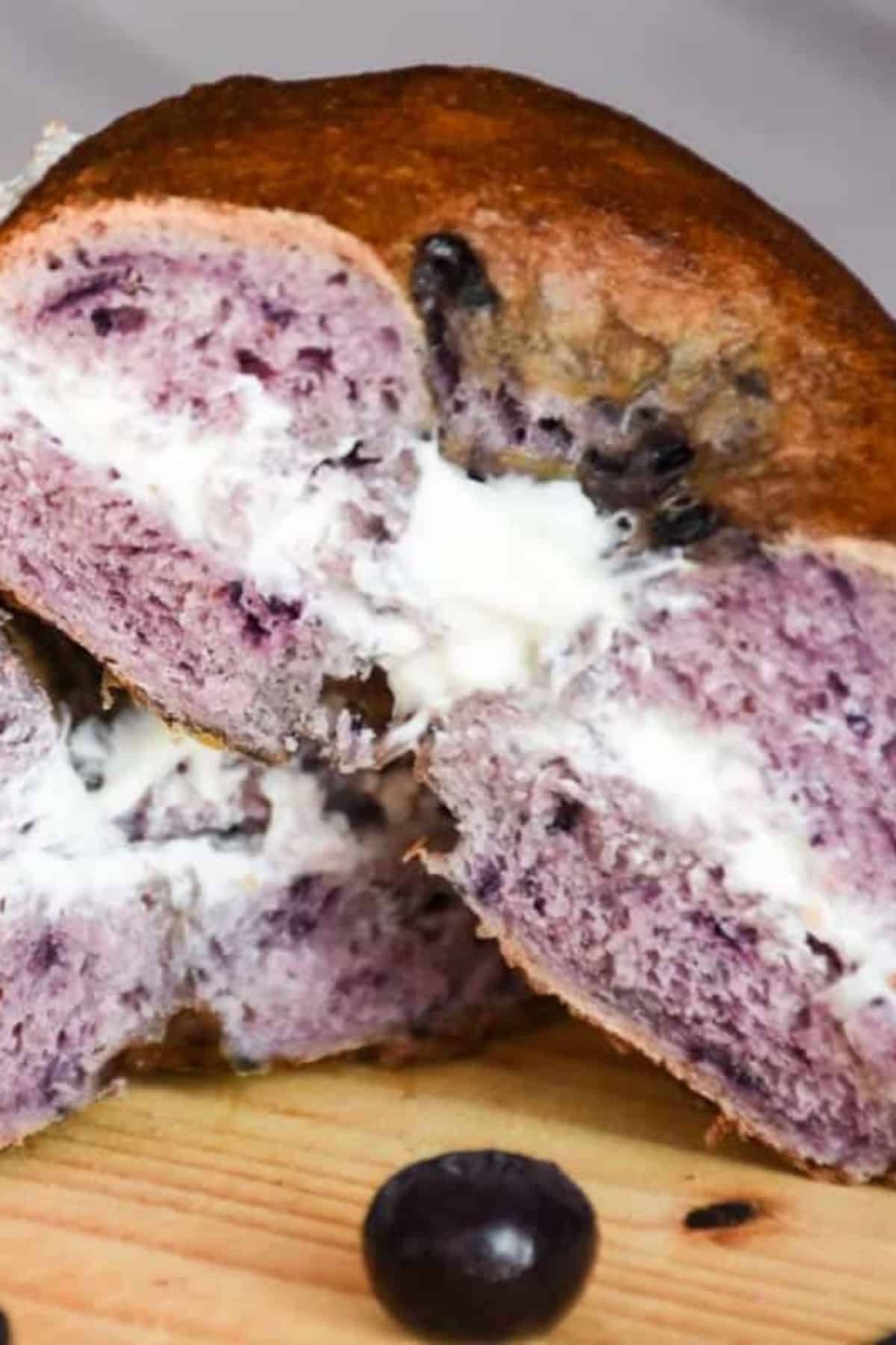Close-up of a blueberry-stuffed pastry revealing creamy blueberry filling inside.