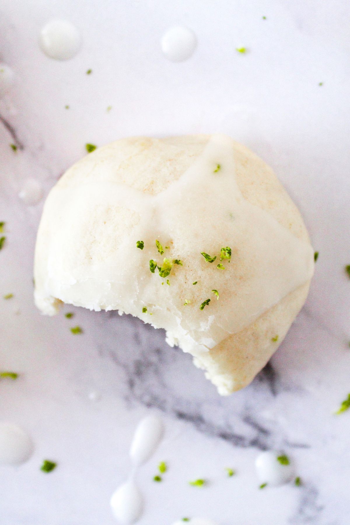 A single sourdough discard key lime ricotta cookie on a surface, showing its texture.
