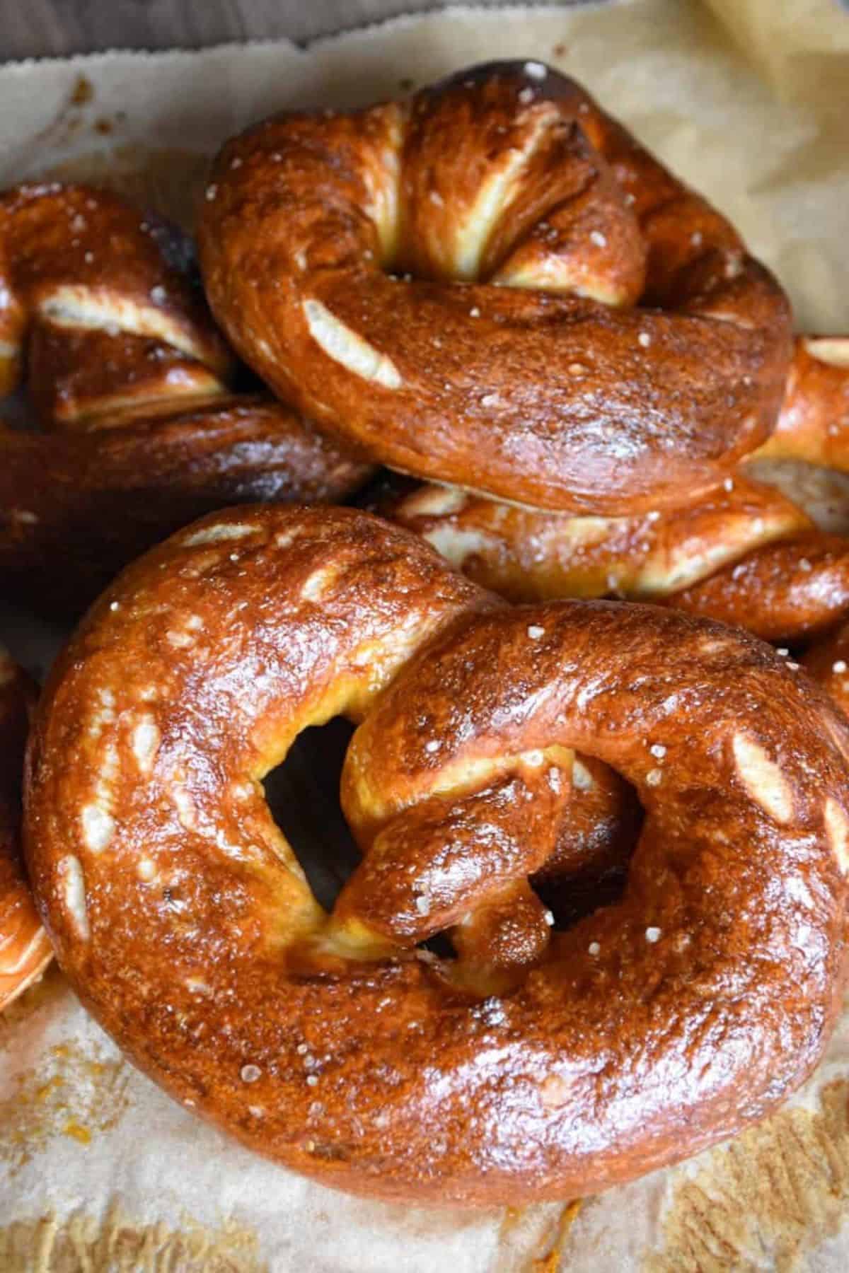 Close-up of glossy sourdough discard pretzels on a surface.
