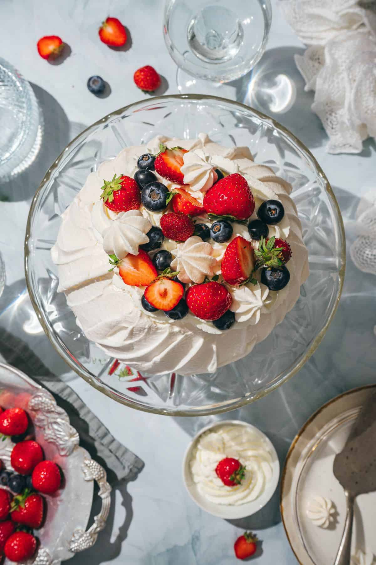 Delicious homemade cake topped with strawberries, blueberries, and whipped cream, perfect for special occasions.