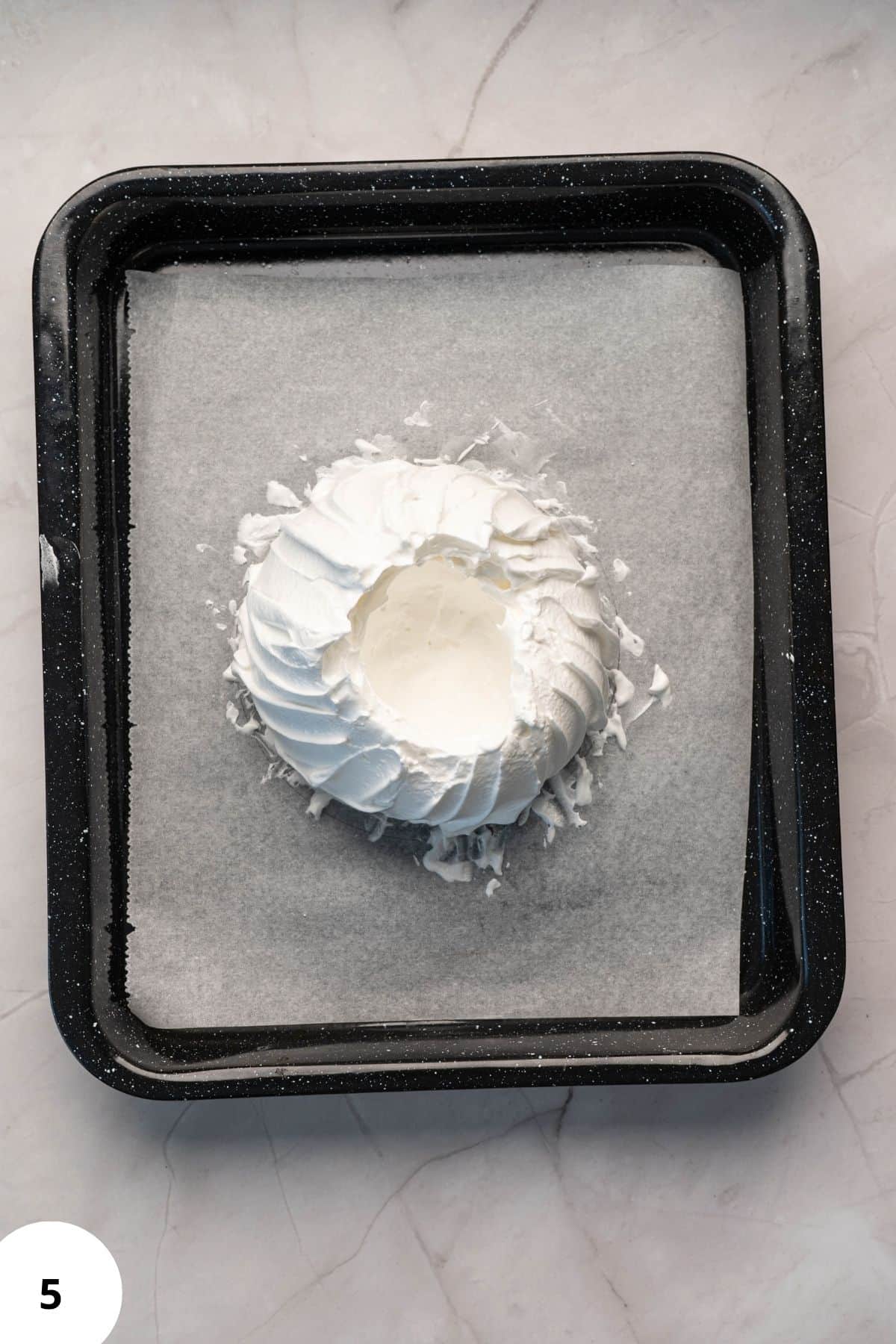 Mixture spread evenly in a tray lined with parchment paper, ready for baking.