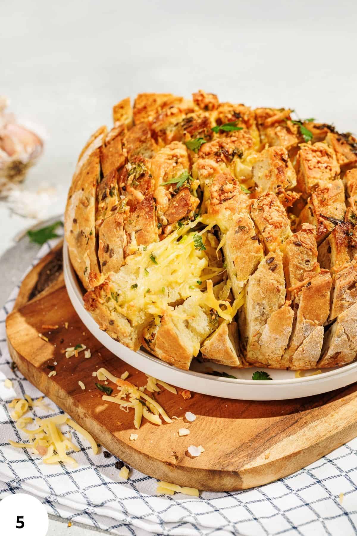Delicious bread bowl filled with cheese, herbs, and savory fillings, perfect for soups or dips.