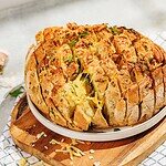 Cheesy baked bread loaf with herbs, featuring a golden crust and gooey interior, ideal for bread lovers and home bakers.