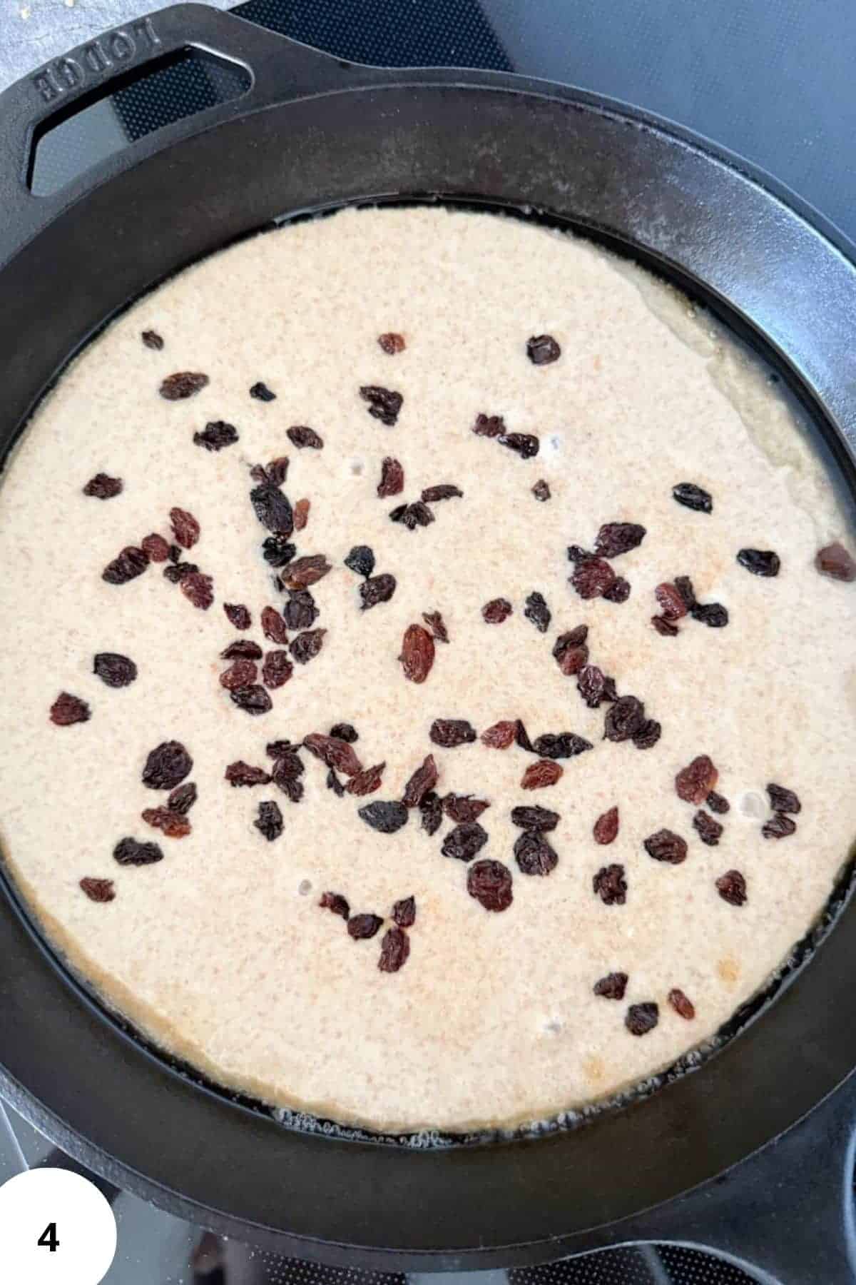 Preparing Austrian shredded pancake batter with raisins in a skillet.