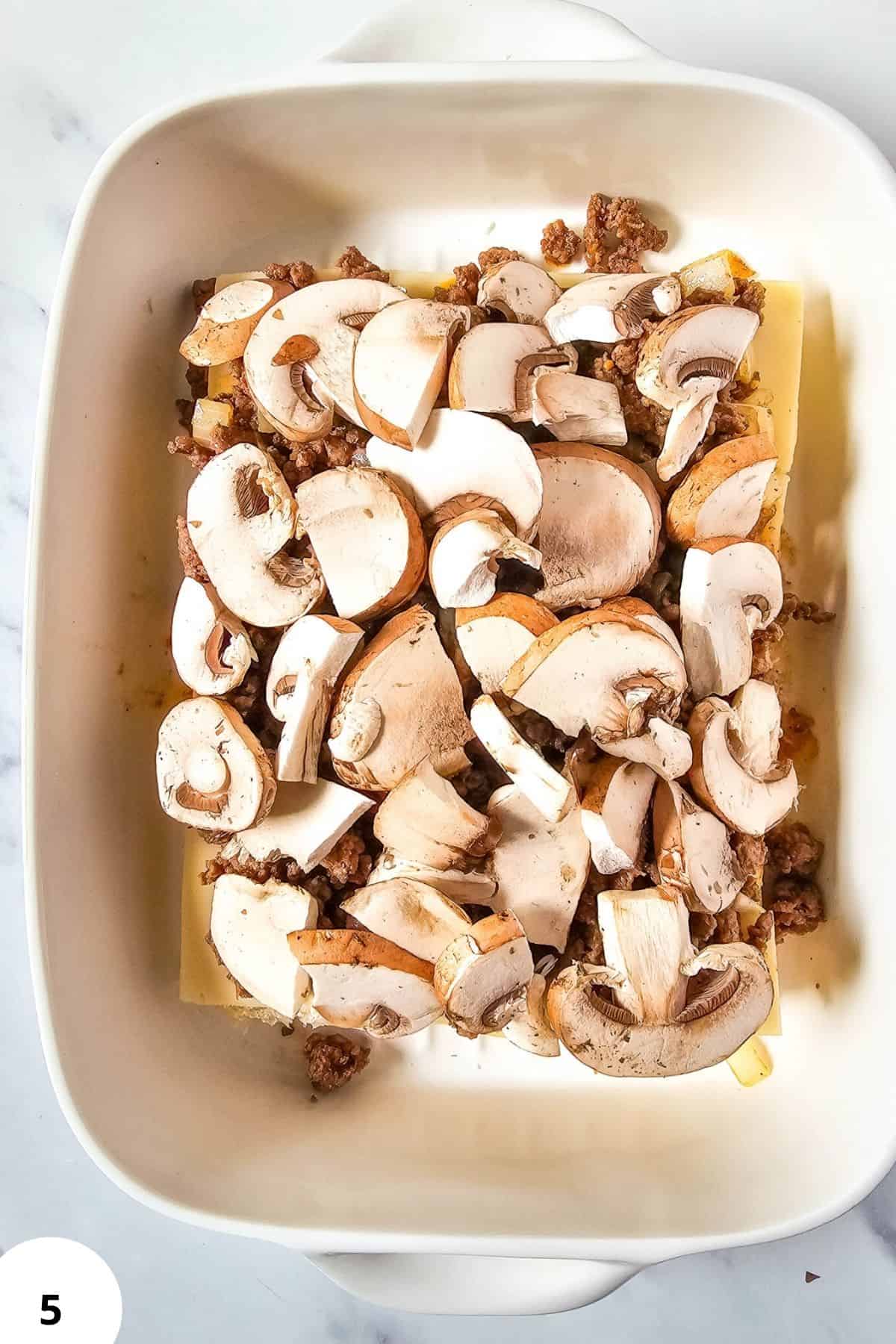 Fresh sliced mushrooms in baking dish.