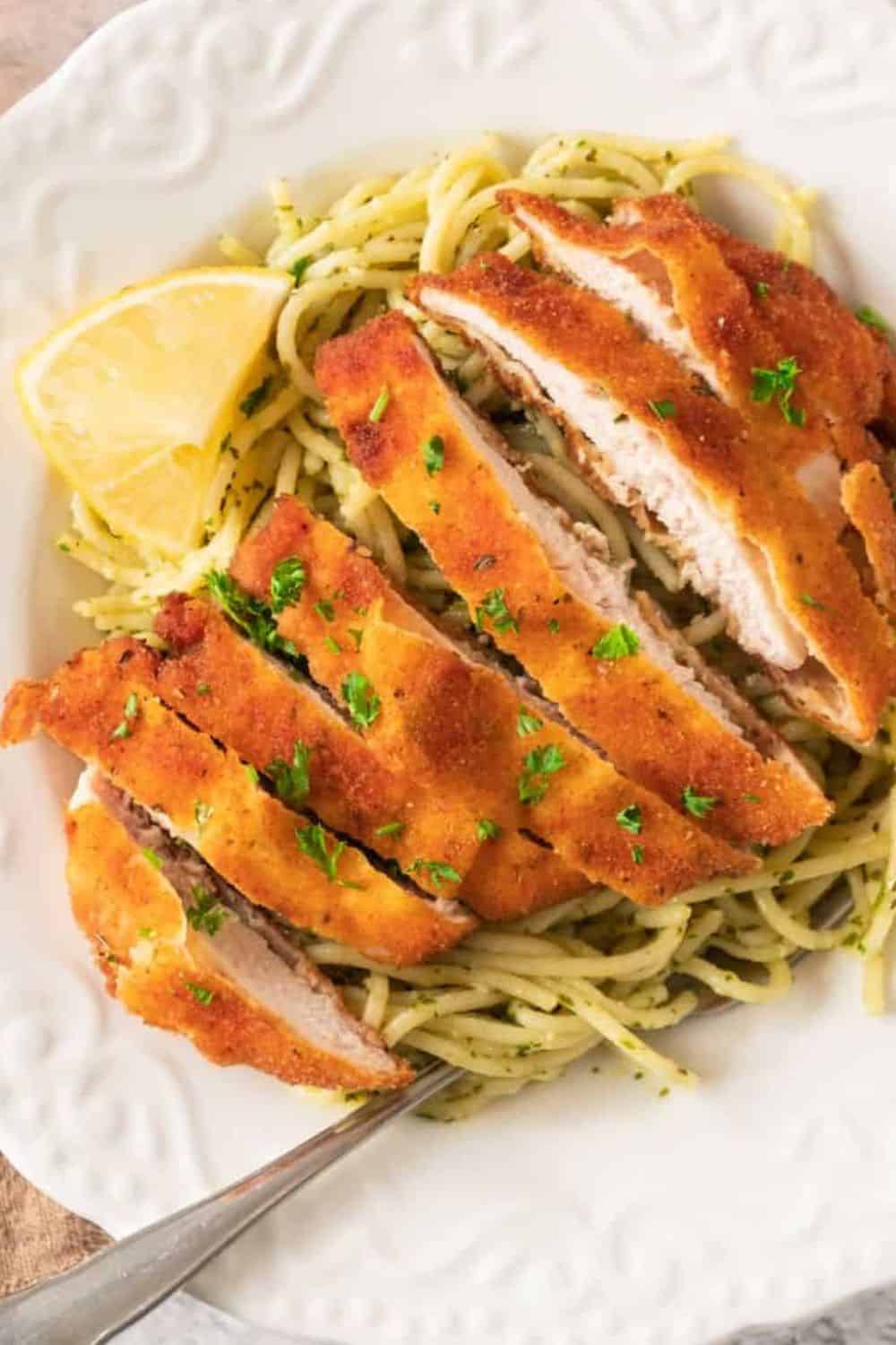 Crispy breaded chicken with pasta and lemon for a delicious meal. Perfect for comforting dinner or lunch.