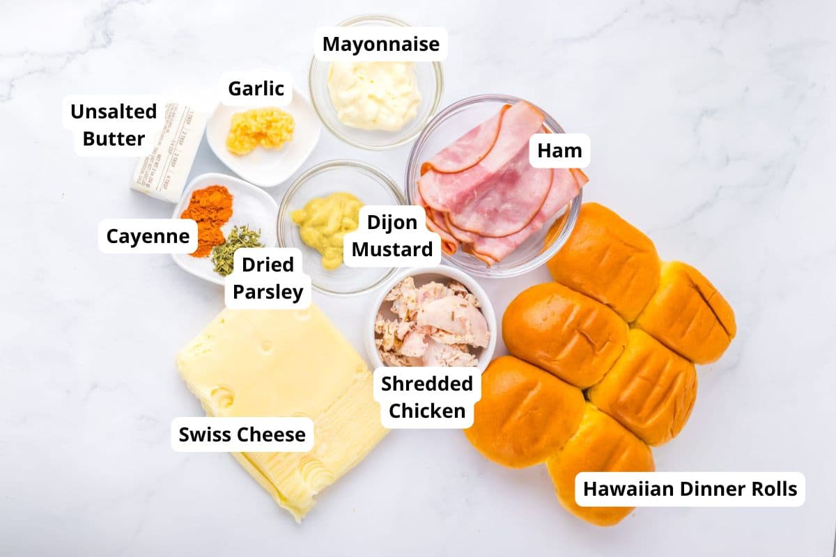 An image showing Hawaiian dinner rolls, ham, shredded chicken, Swiss cheese, mayonnaise, Dijon mustard, dried parsley, cayenne, garlic, unsalted butter, and mayonnaise.