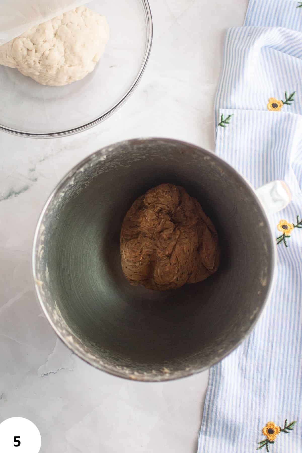 Alt text: Fermentation dough in a metal container with initial dough preparation for bread.