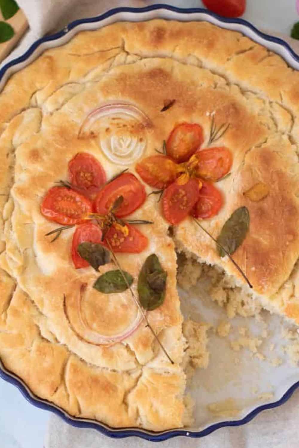 Freshly baked savory pie topped with tomatoes, herbs, and a golden crust, perfect for baking enthusiasts and bread lovers.