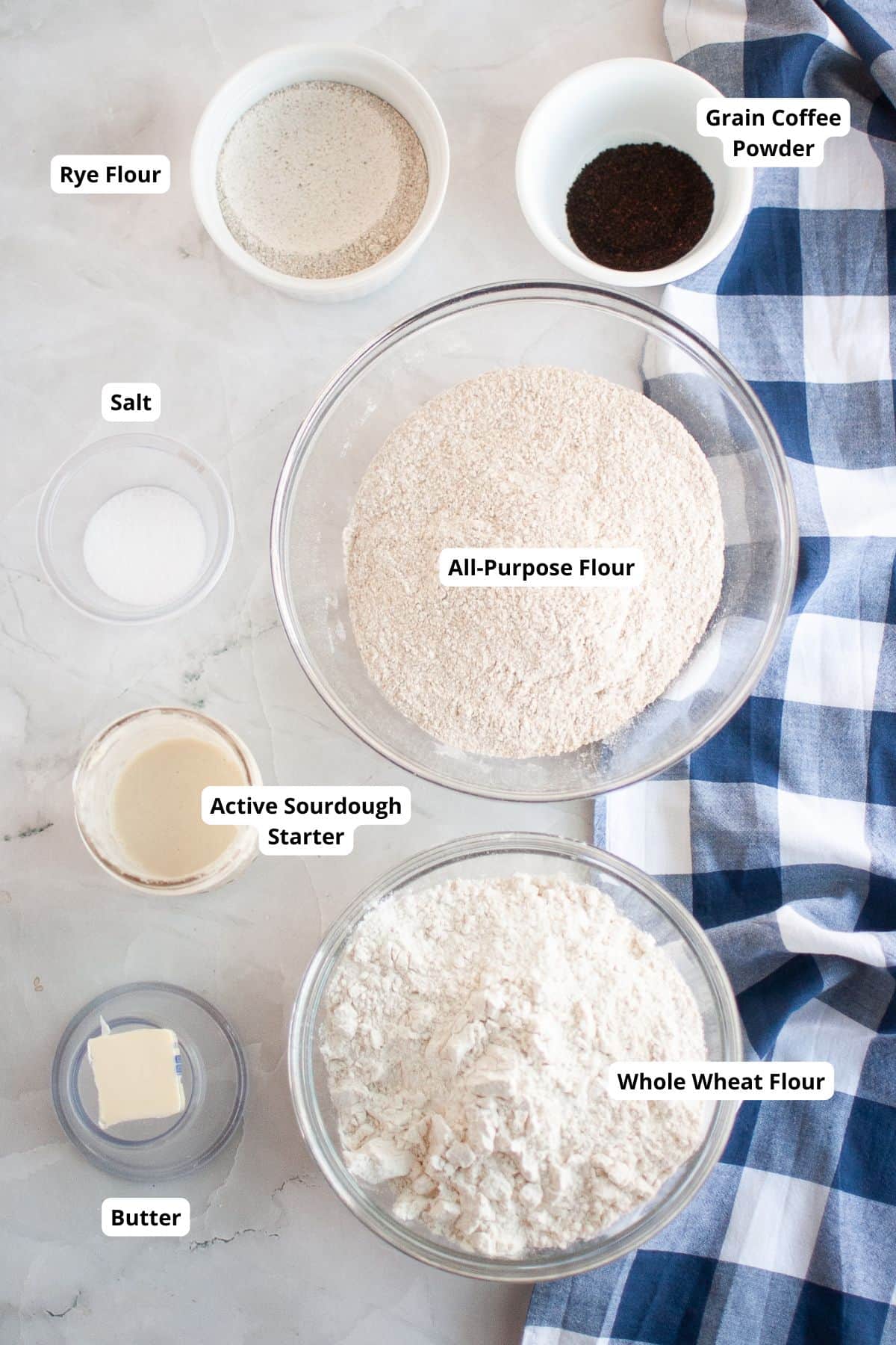 Fresh ingredients for sourdough bread baking with stretch and fold techniques. High-quality flours and starter ready for mixing.