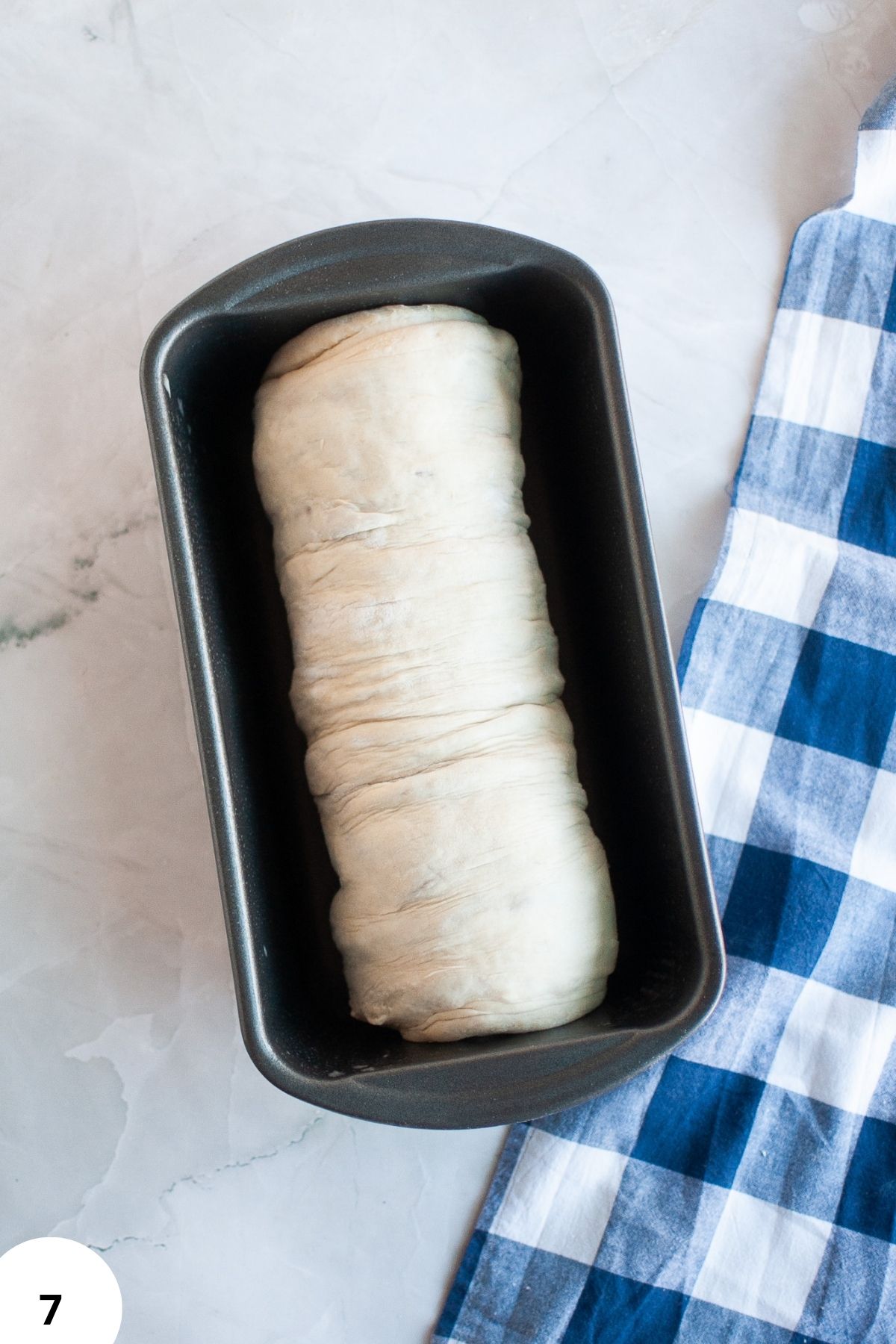 Artisan bread dough in a loaf pan, perfect for shaping with stretch and fold method.