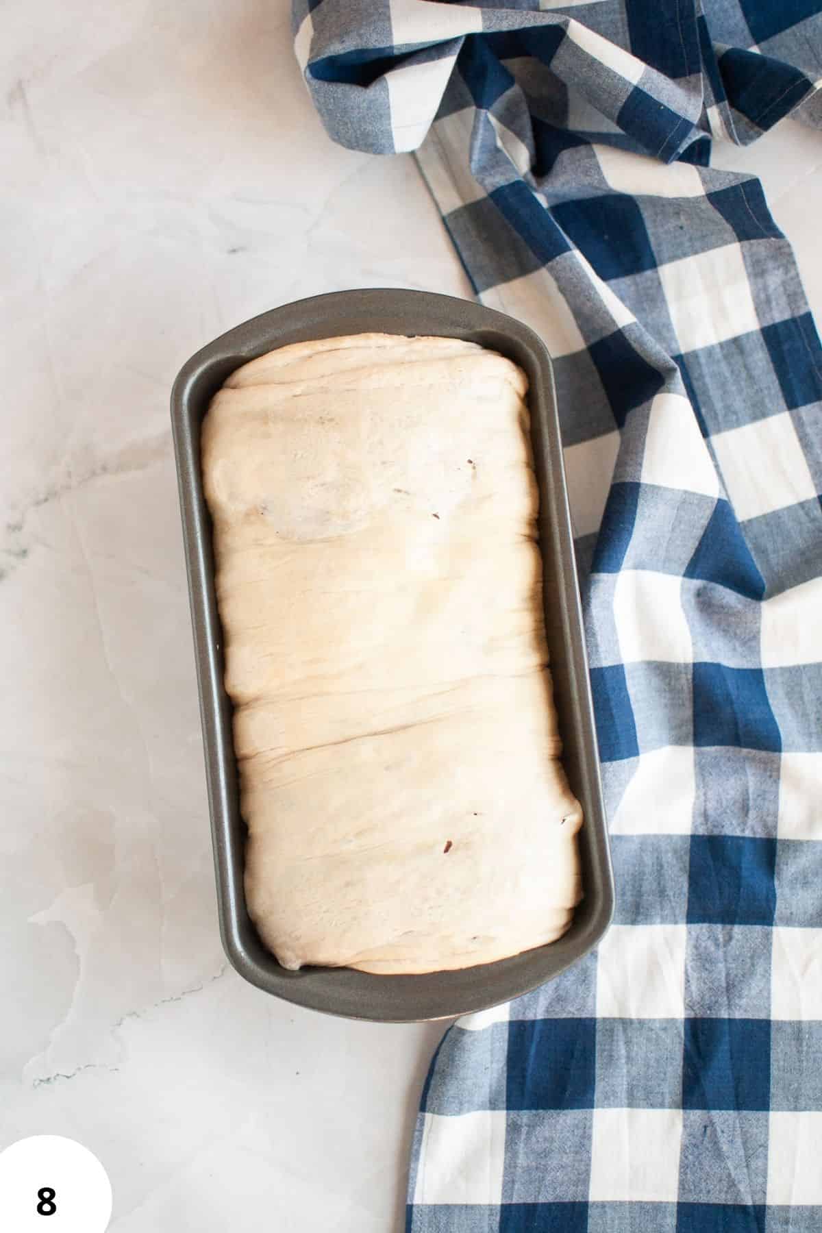 Fresh bread dough in a pan, prepared for the next step in bread making, showcasing stretch and folds technique.