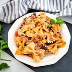Delicious homemade pasta with beans, corn, vegetables, and ground beef, garnished with cilantro.