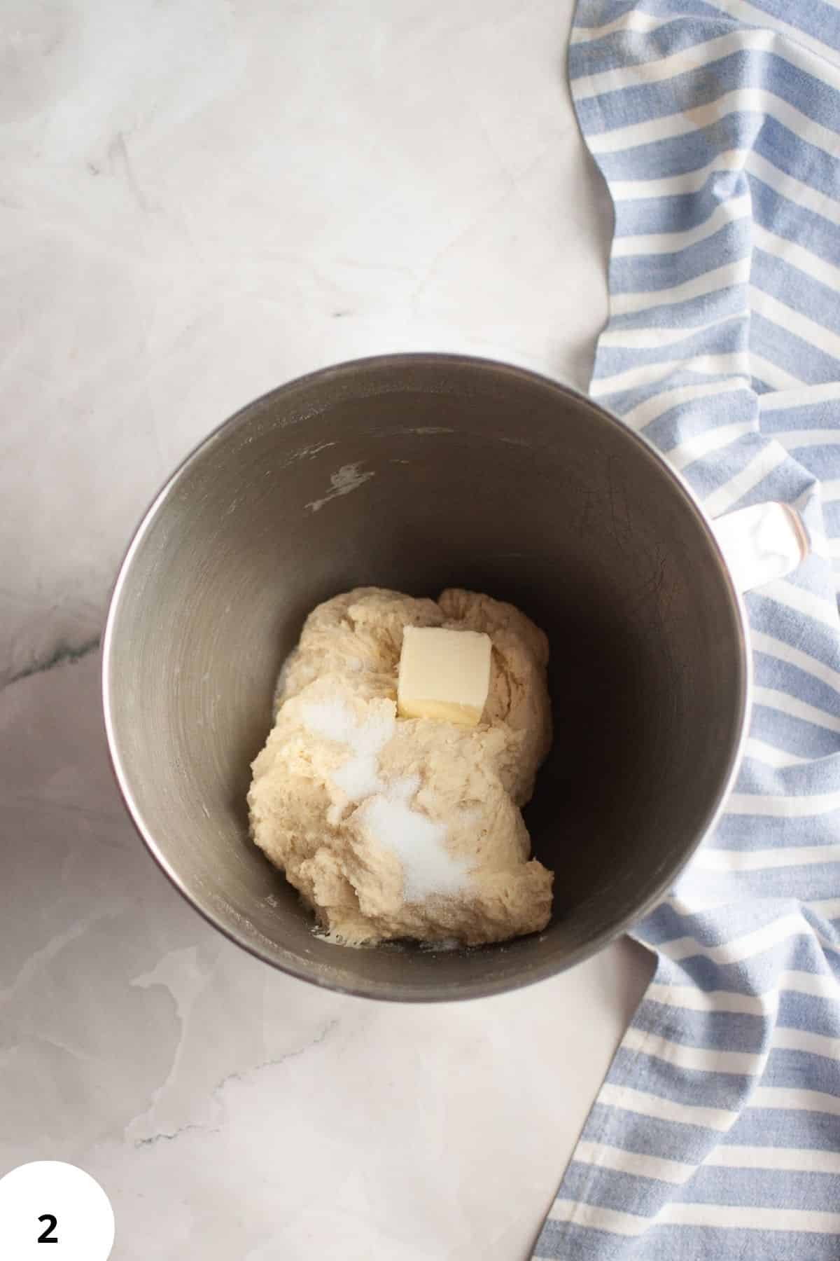 Soft dough with butter in mixing bowl for bread making.