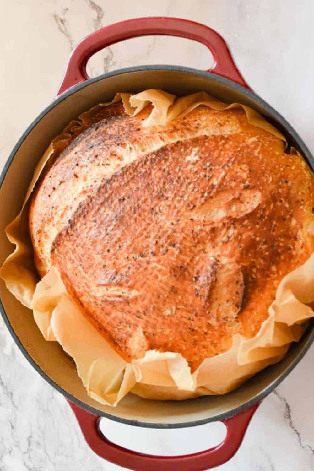 Delicious artisan bread proofing in Dutch oven, showcasing bread making and baking skills.