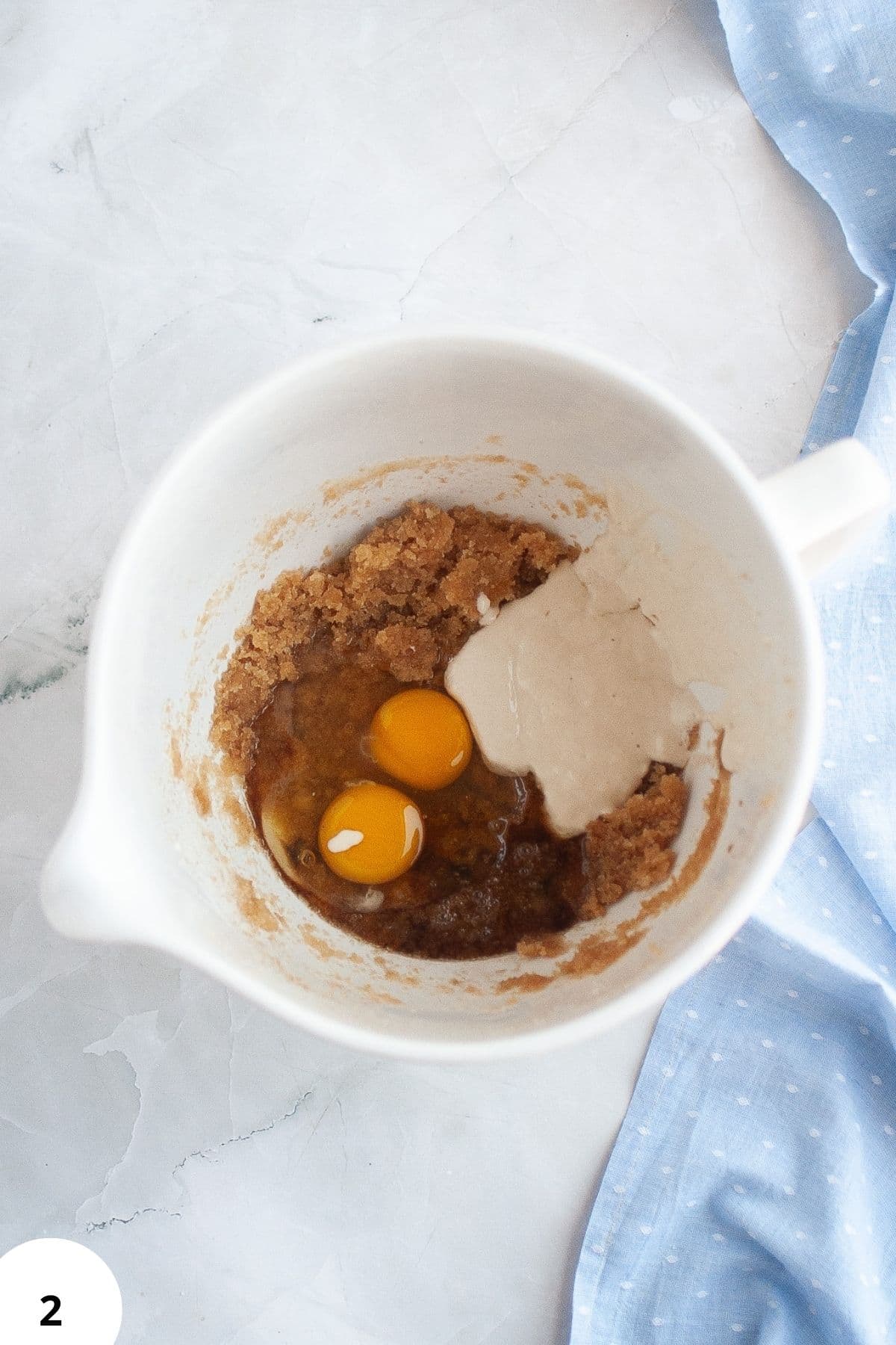Egg and dough ingredients in a mixing bowl for bread baking.