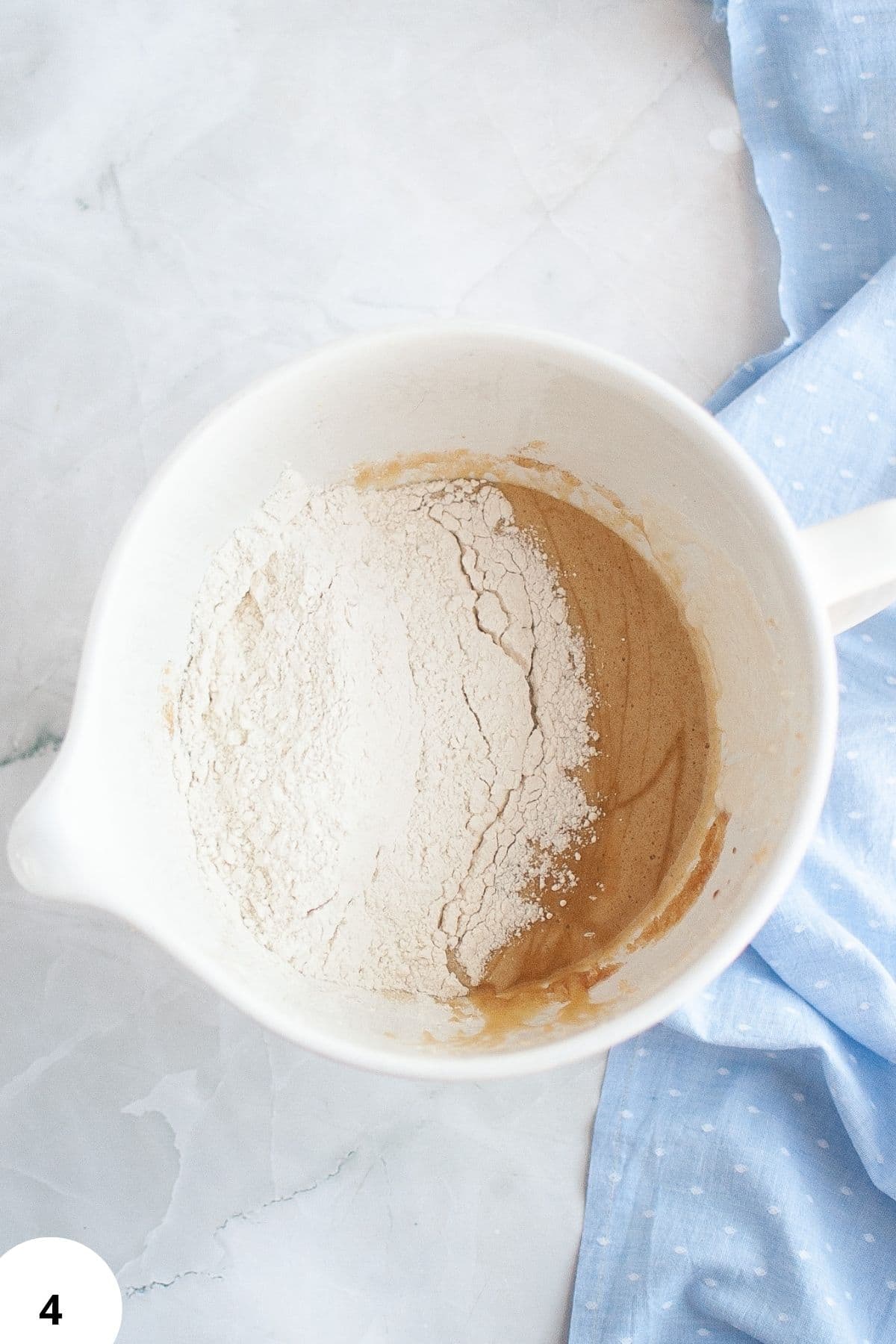 Flour and water mixture for bread making in a white pitcher.