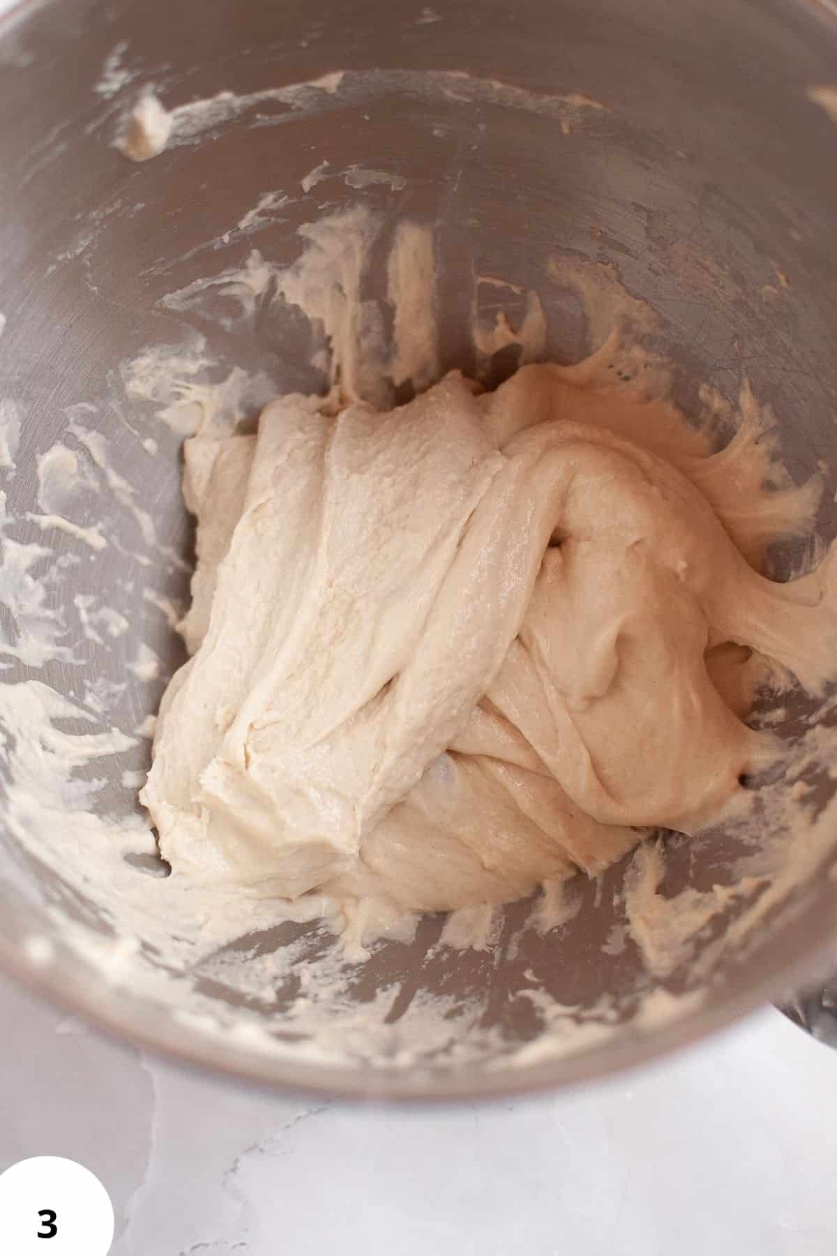 Stretch and folds dough for artisan bread preparation.