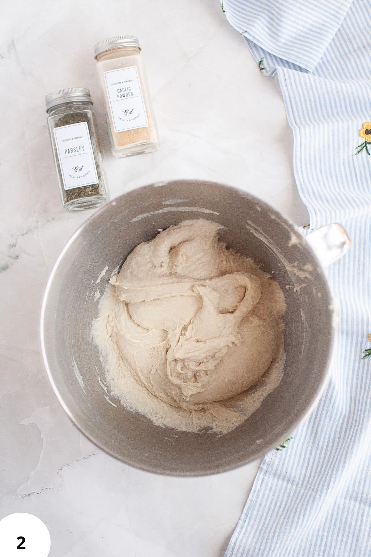 Fresh bread dough ready for shaping and proofing with herbs on top.