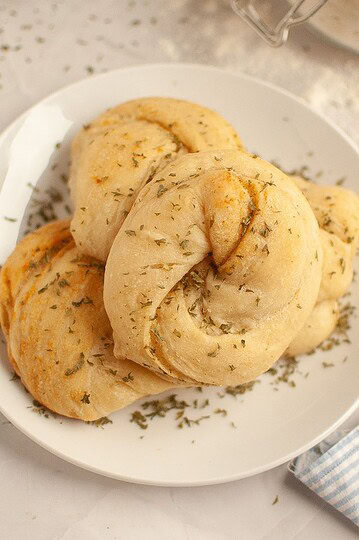Freshly baked bread rolls seasoned with herbs, ideal for baking and bread recipes.