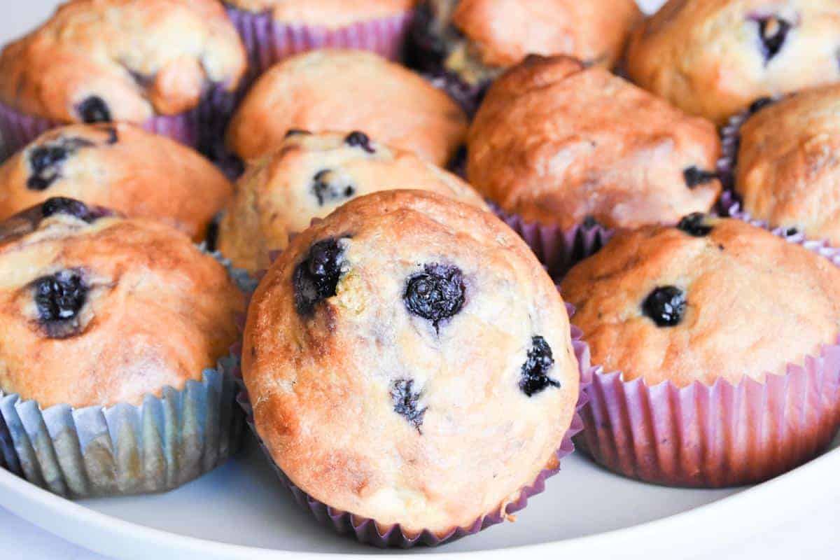 Delicious homemade blueberry muffins baked to perfection in colorful paper liners, showcasing a golden crust and juicy blueberries.