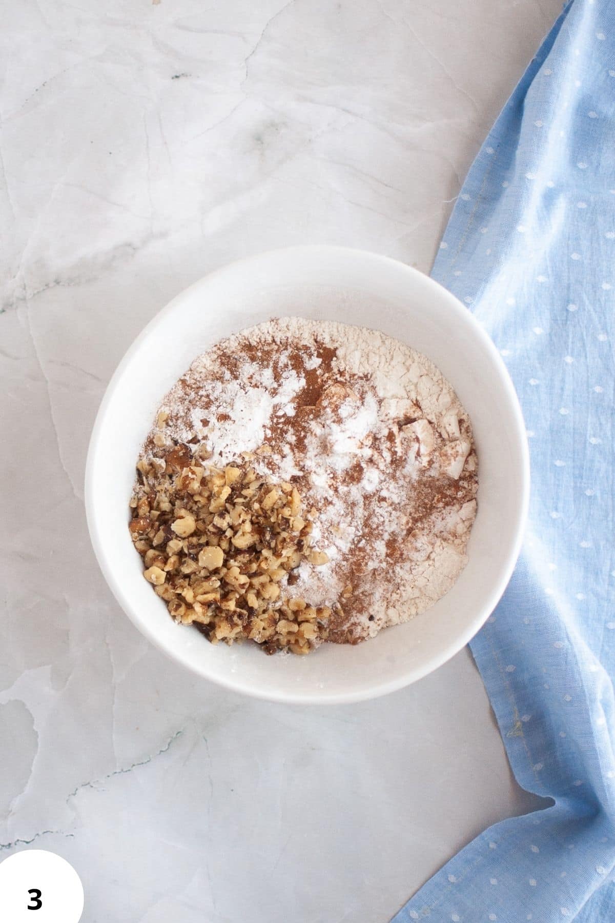 Sourdough discard, grated zucchini, walnuts, flour, and spices in a bowl for bread.