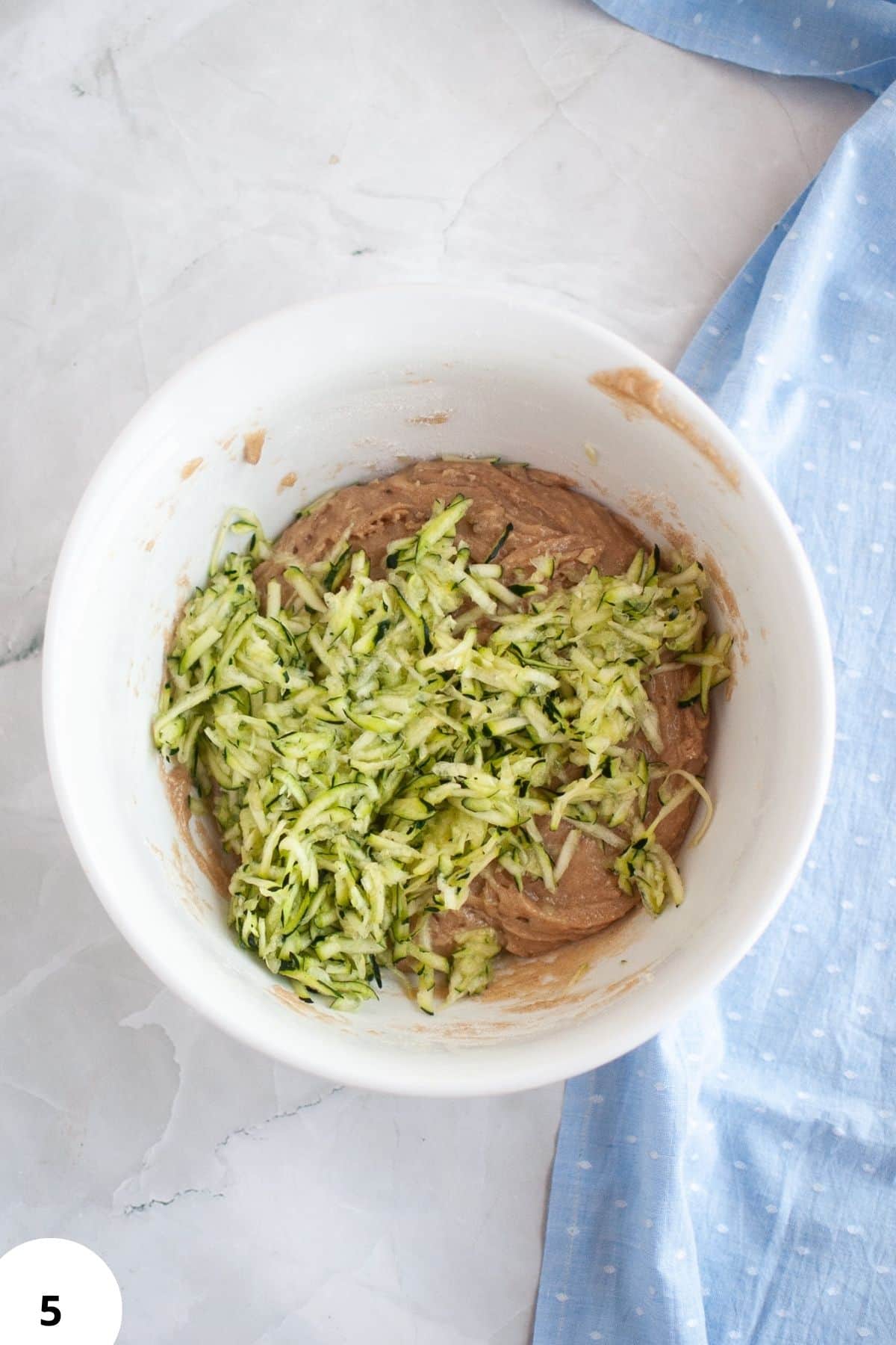 Sourdough bread dough with zucchini and walnuts during stretch and fold process.