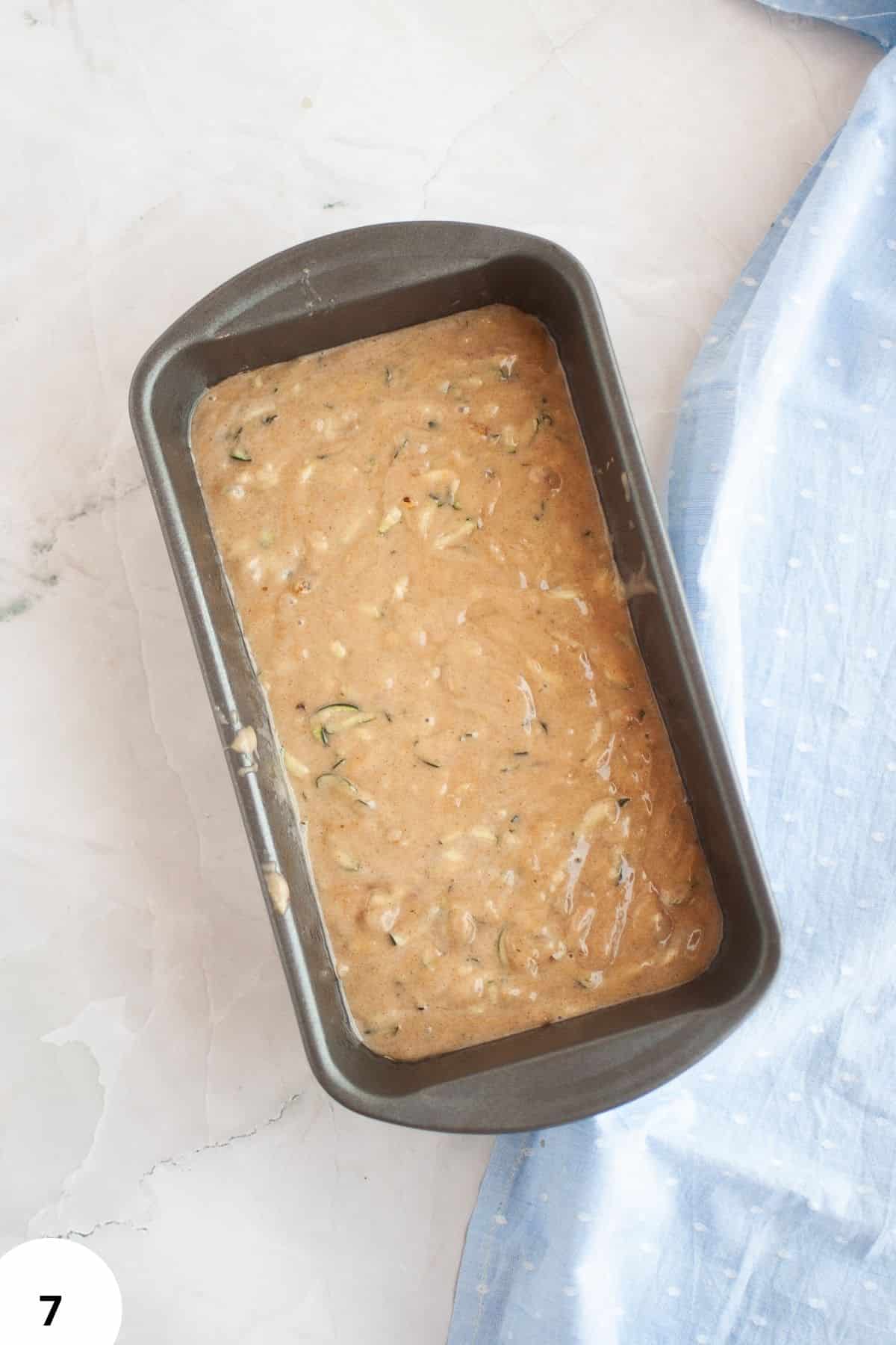 Easy sourdough discard zucchini bread with walnuts in a baking pan.