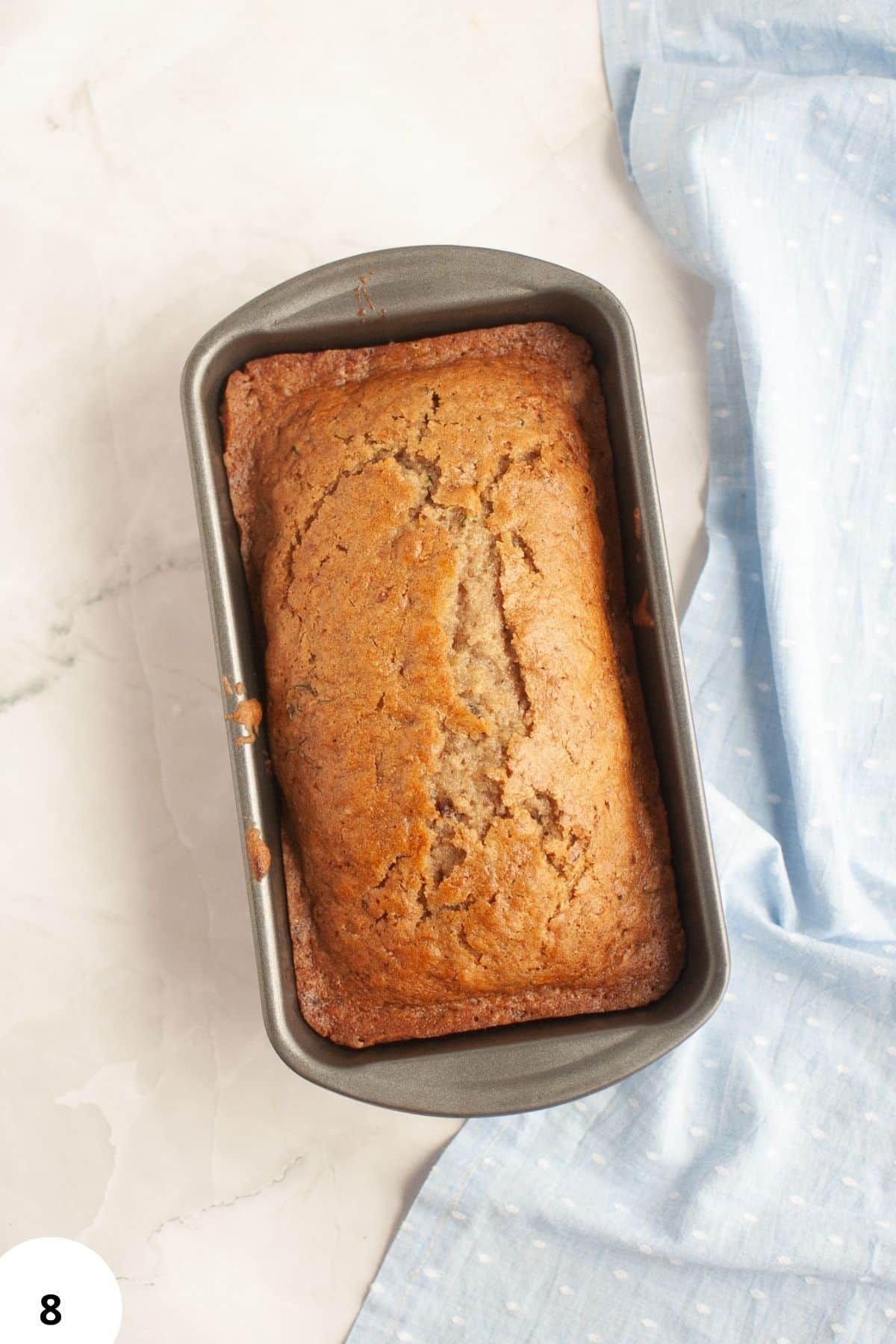 Sourdough discard zucchini bread with walnuts, fresh and golden, baked in a loaf pan.