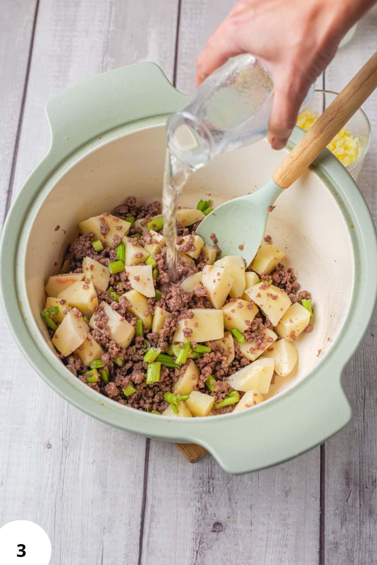 Demonstrating stretch and fold technique on bread dough in a mixing bowl.