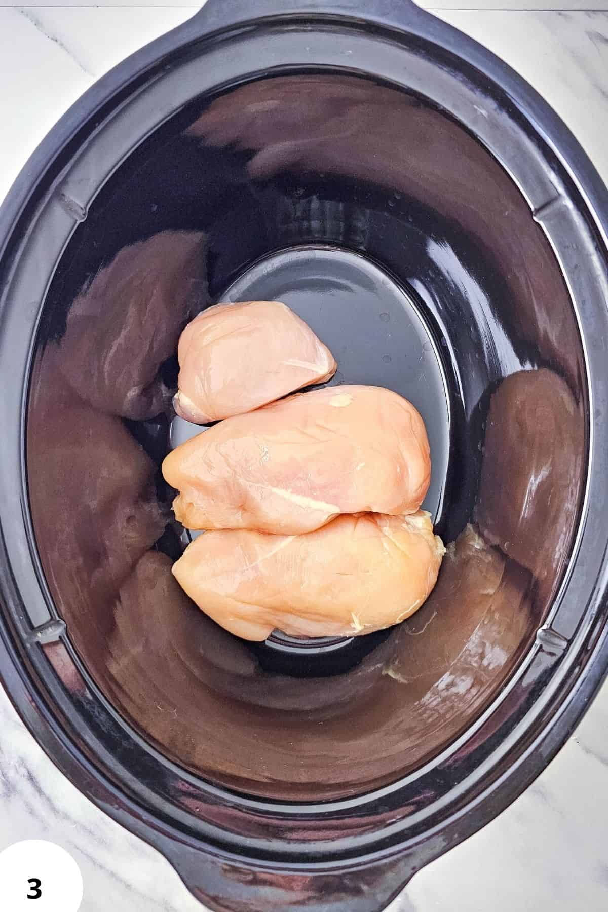 Chicken breasts in a slow cooker for stretch and folds technique.