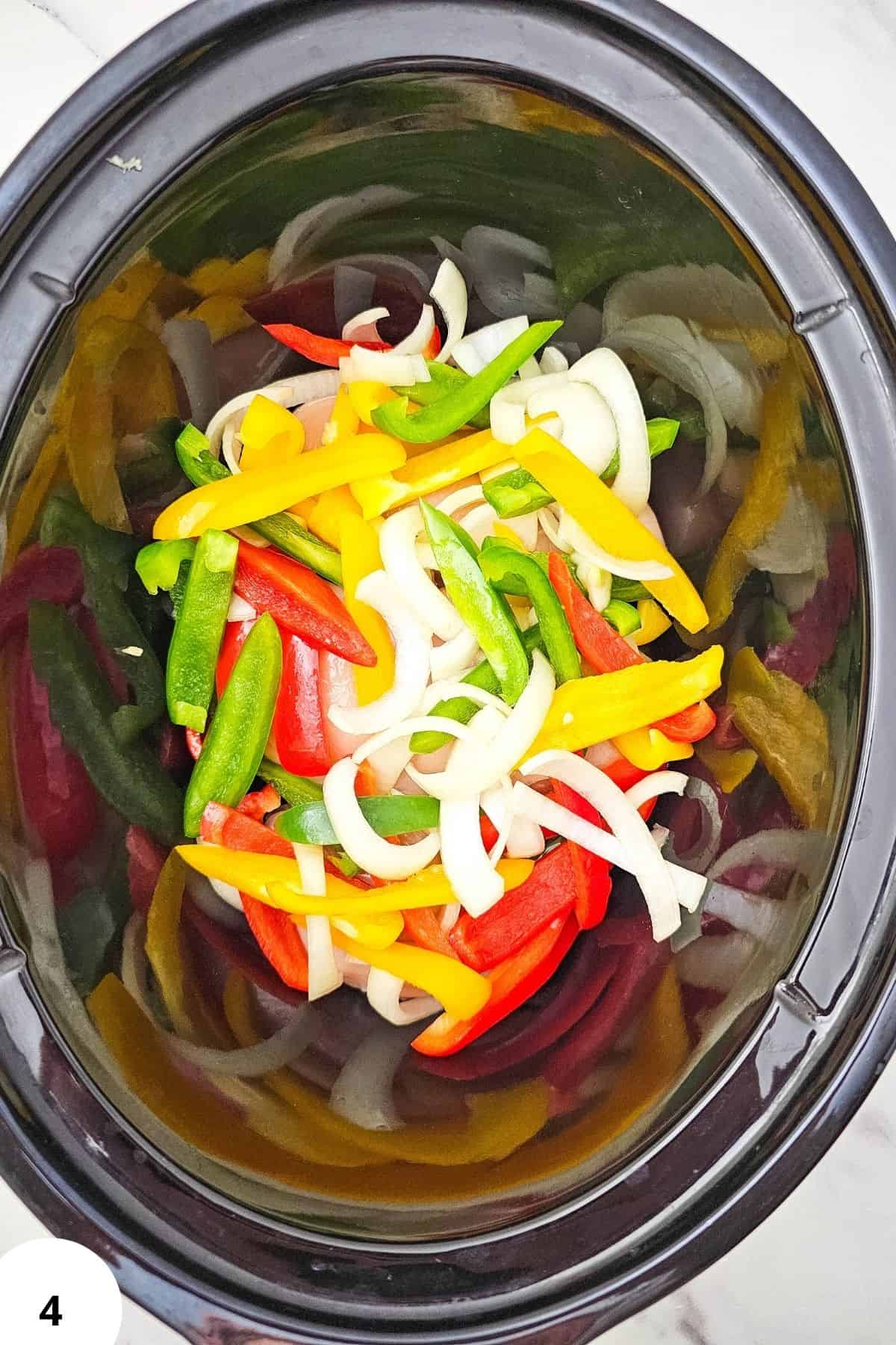 Close-up of colorful sliced vegetables in a slow cooker for fajitas.