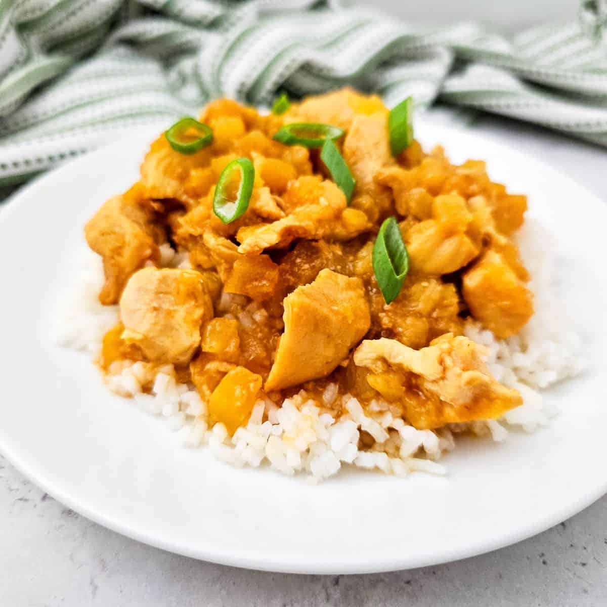 Delicious slow cooker Hawaiian chicken served over rice with green onions. Perfect for easy, flavorf.