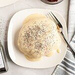 Creamy bread topped with poppy seeds, served on a white dish.