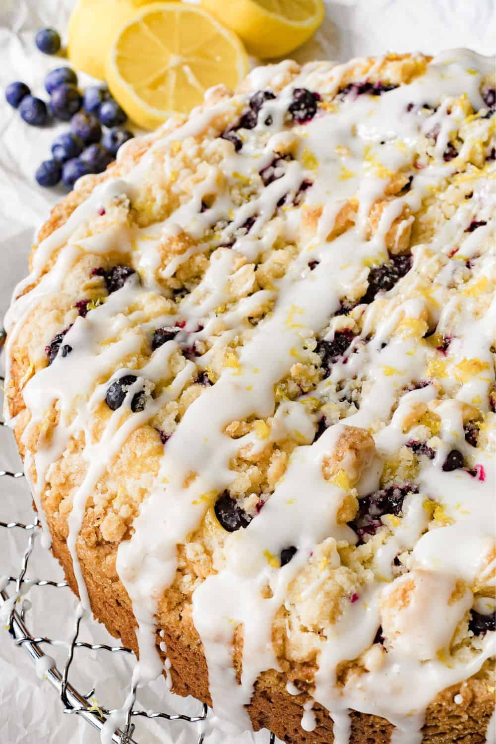 Delicious blueberry lemon cake with icing and fresh berries on top.