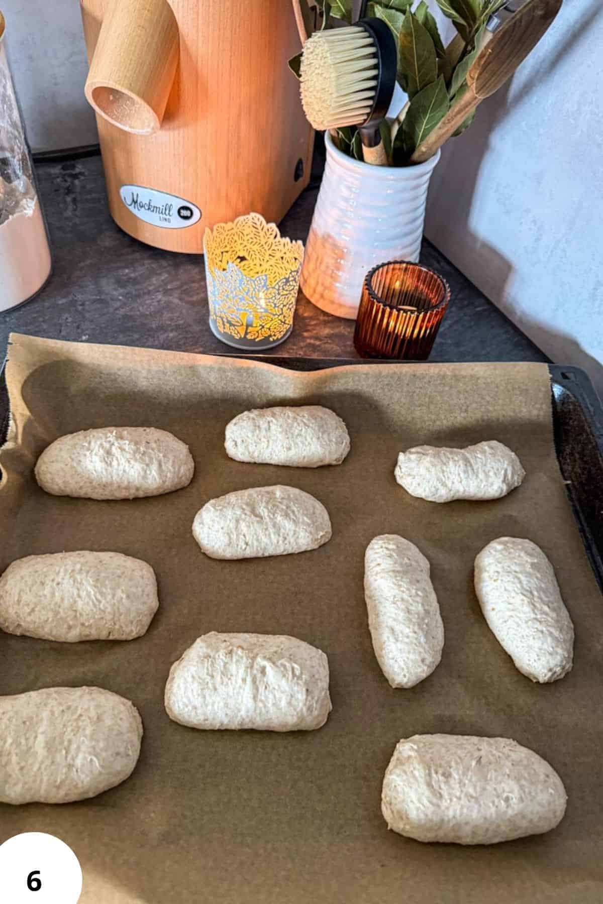 Unbaked bread rolls on baking tray ready for proofing.