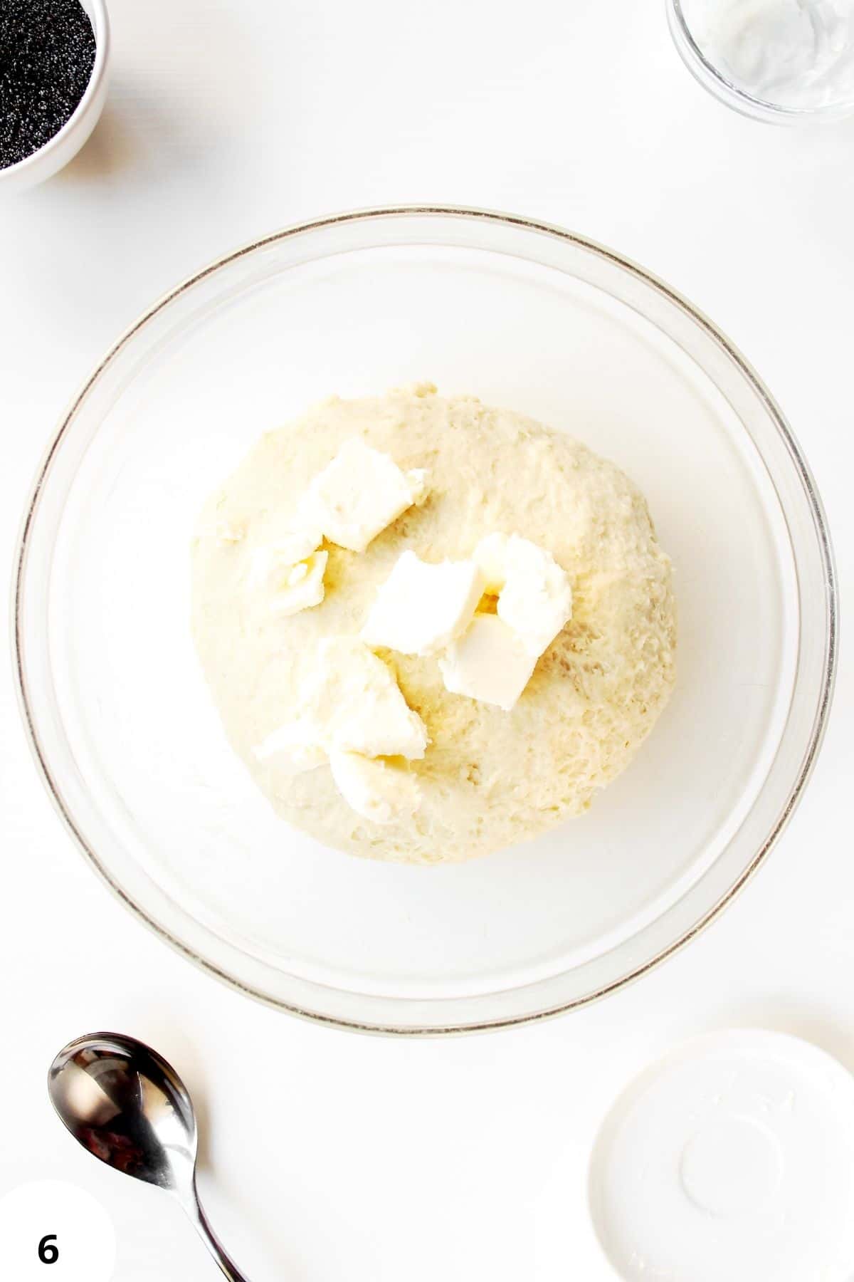 Sourdough dough with butter resting in a glass bowl for stretch and folds.