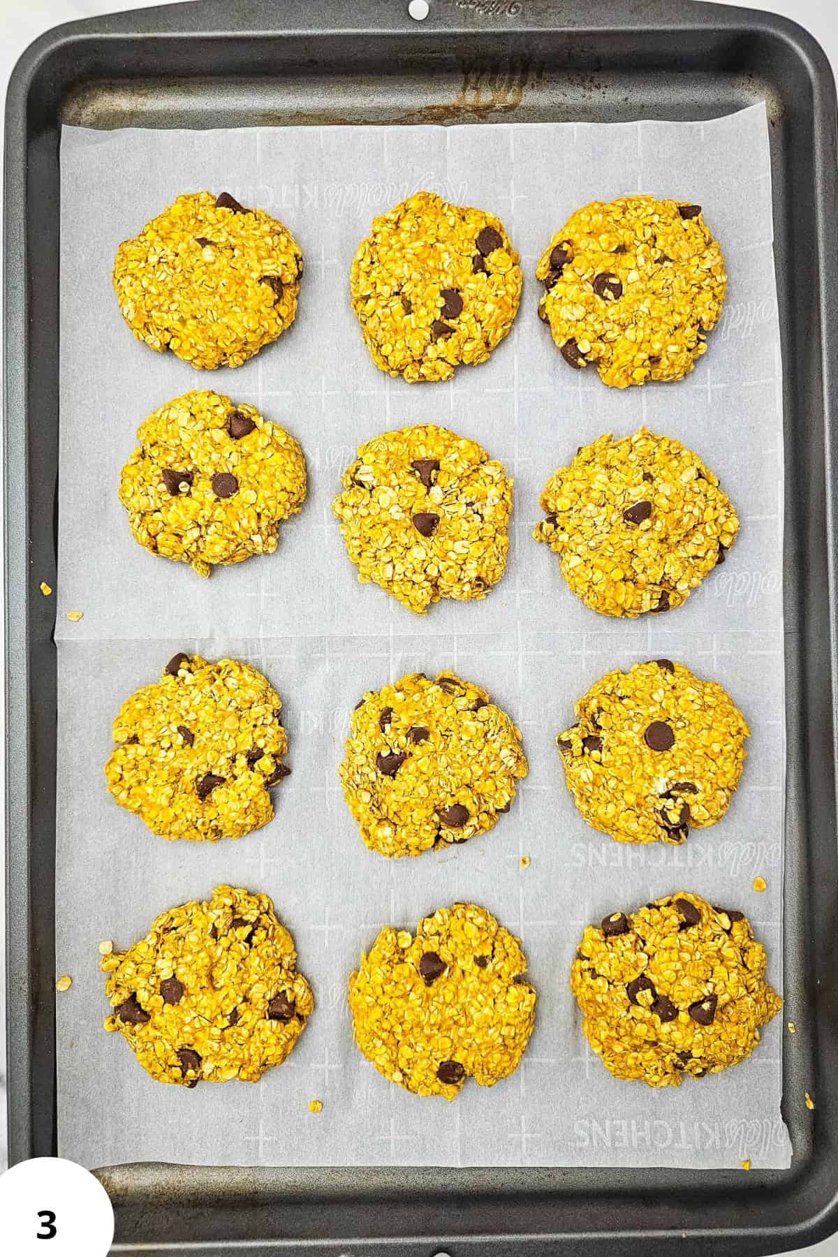 Healthy pumpkin oatmeal cookies with chocolate chips on a baking sheet.