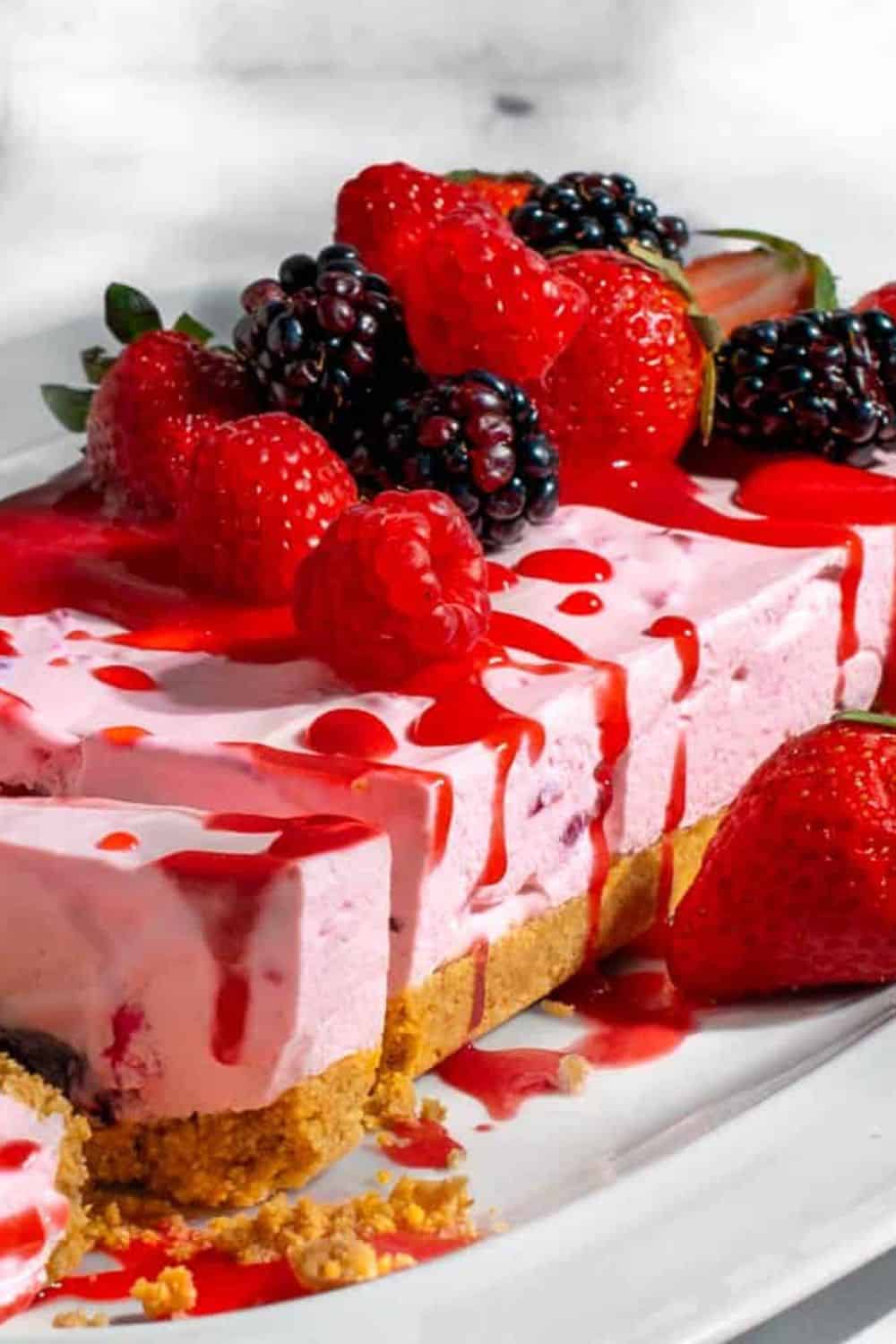 Delicious strawberry and mixed berry cheesecake with a graham cracker crust and berry drizzle. Perfe.