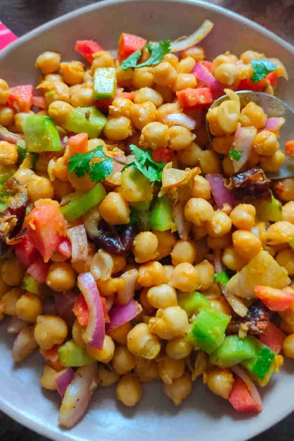 Healthy chickpea salad with colorful vegetables and herbs.