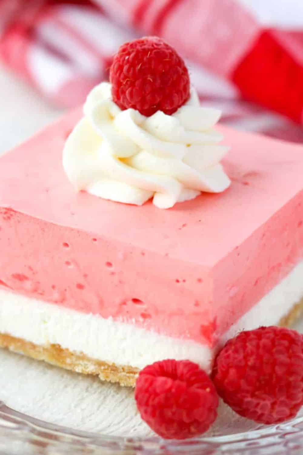Raspberry cheesecake with whipped cream topping and fresh raspberries. Perfect for dessert lovers an.