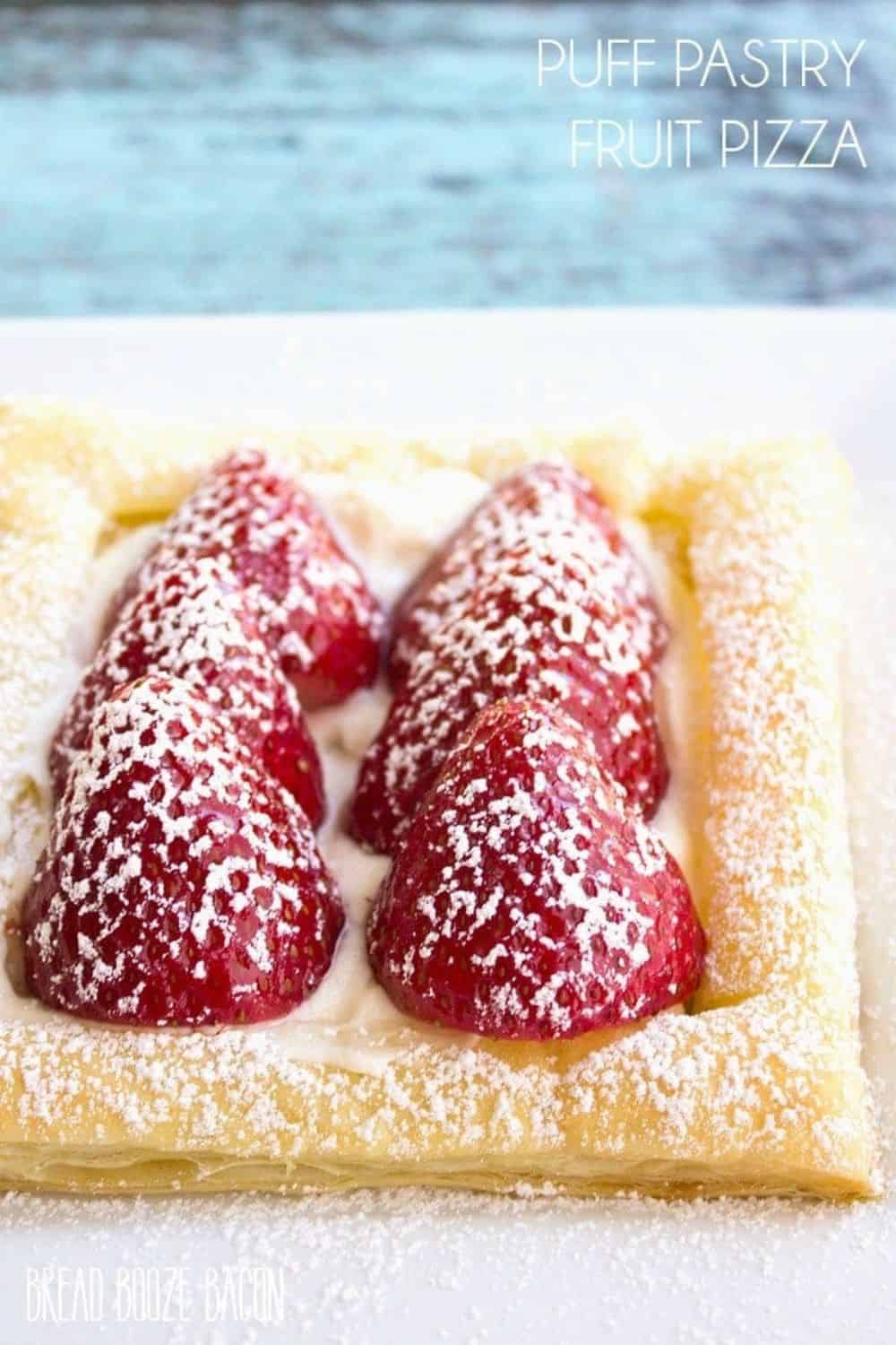 Fresh puff pastry fruit pizza with strawberries and powdered sugar.