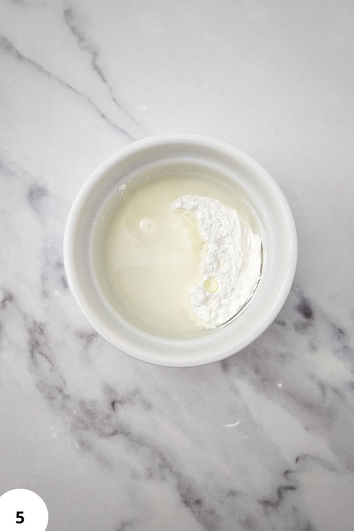 Bowl of creamy dough mixture ready for stretch and fold technique.
