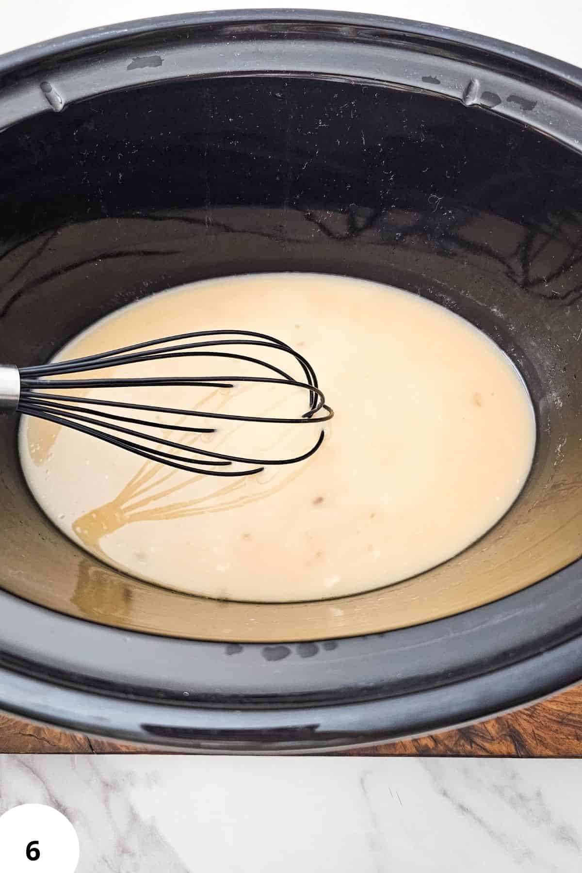 Creamy sauce in a slow cooker, ready for chicken marsala preparation.