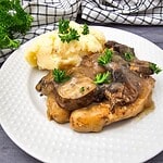 Slow Cooker Chicken Marsala served with mashed potatoes and fresh herbs.