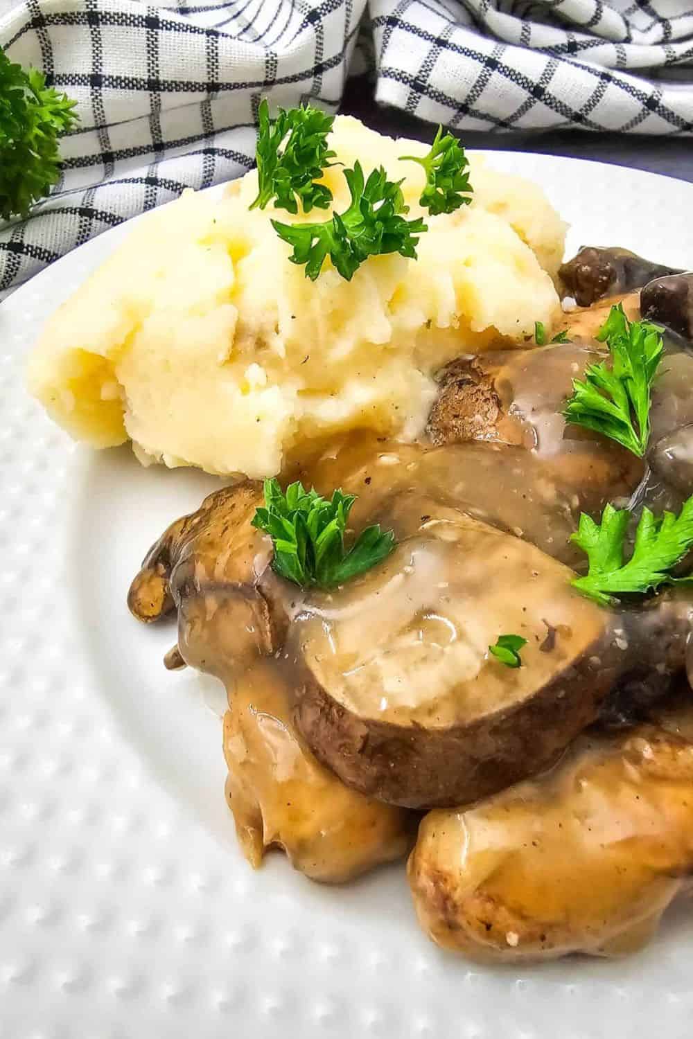 Creamy mushroom dish with mashed potatoes and fresh parsley garnish.