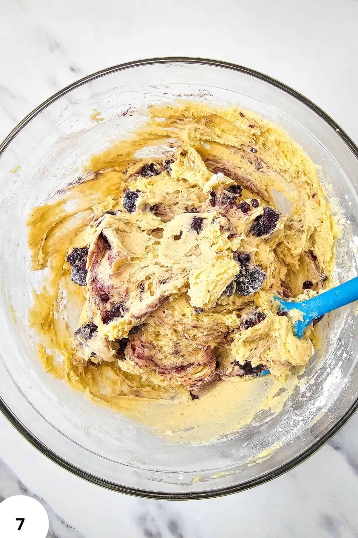 Blackberry muffin batter with stretch and folds in a glass mixing bowl.