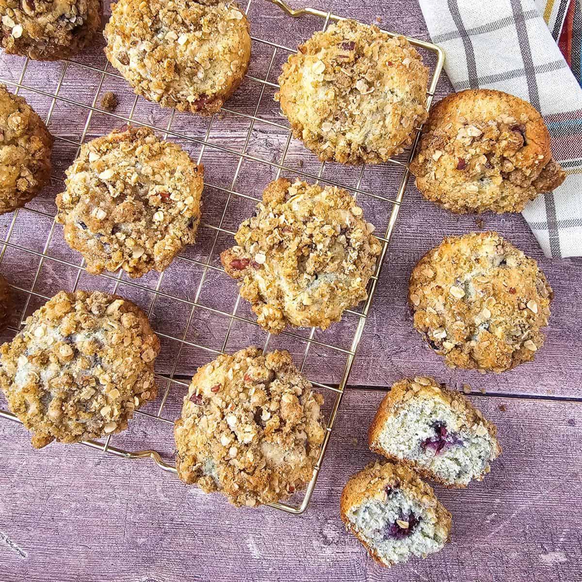 Freshly baked blackberry muffins with streusel topping on a cooling rack.