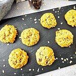 Freshly baked oatmeal raisin applesauce cookies on a black slate board.